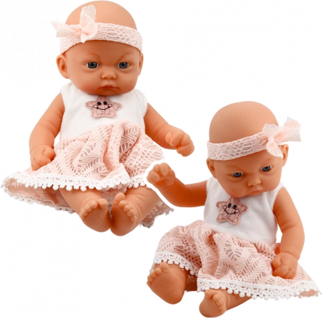 Babypuppe im rosa Kleid mit Haarband
