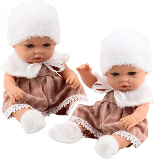 Babypuppe in beigefarbenem Kleid mit Mütze und Kragen