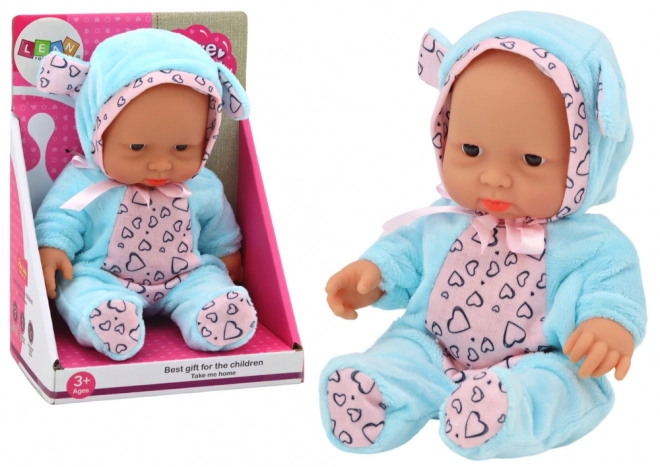 Kleine Baby-Puppe mit Schleife und blauer Mütze