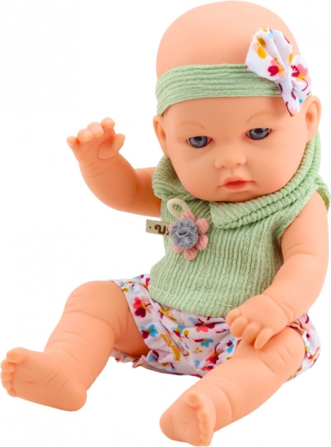 Baby-Puppe im grünen Outfit mit Blumenmuster und Haarband mit Schleife
