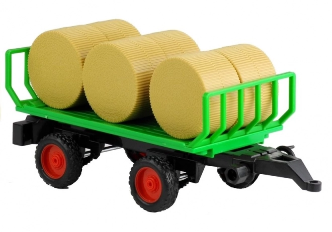 Grüner Traktor mit Anhänger und Heu